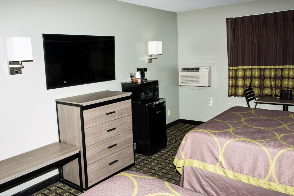 Guest room with TV, dresser and mini-fridge, Michigan City hotel